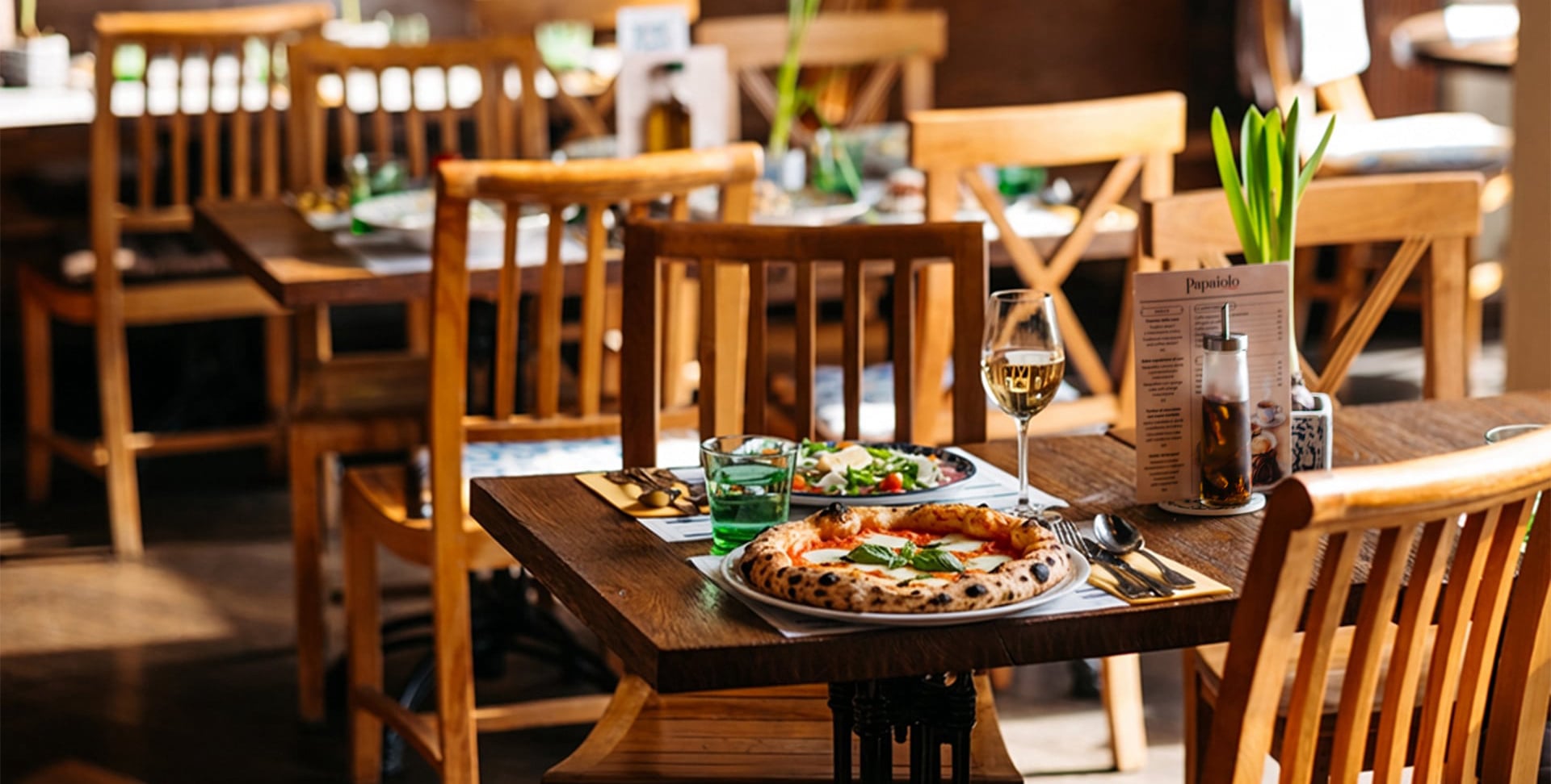 Kamenná pec na dřevo s plamenem a čerstvě připravovanou neapolskou pizzou