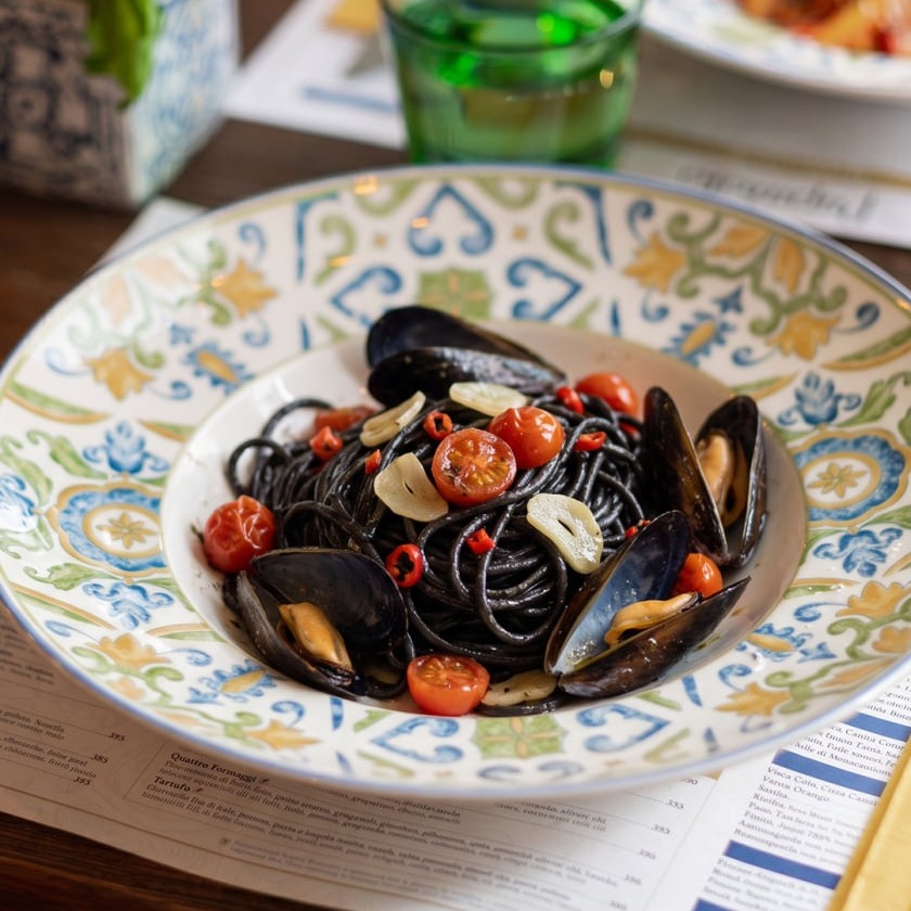 Squid ink spaghetti with mussels, cherry tomatoes, garlic, and chili