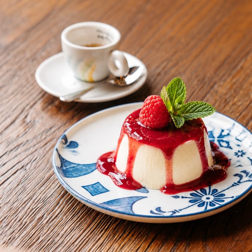 Vanilla panna cotta with raspberry coulis, fresh raspberry, and mint at Papaiolo restaurant