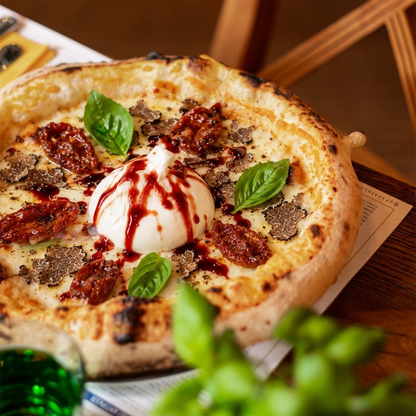 Neapolitan pizza with burrata, sun-dried tomatoes, black truffle, and red balsamic glaze