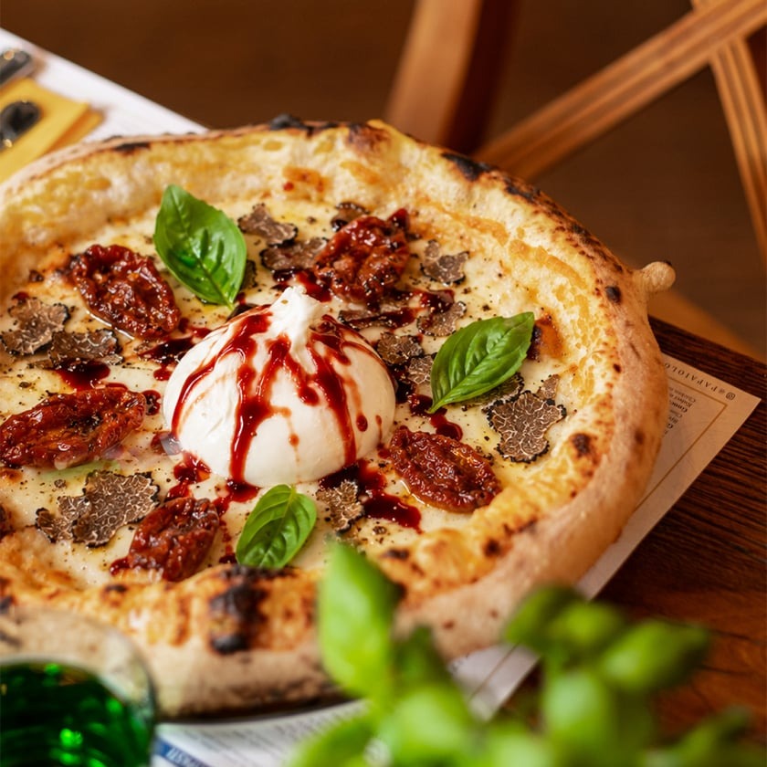 Pizza napoletana con burrata, pomodori secchi, tartufo nero e glassa di aceto balsamico rosso